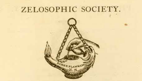 A hand pouring oil into an ignited lantern, logo of the Zelosophic Society.
